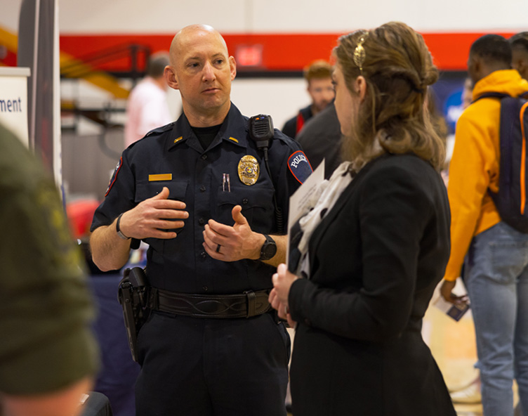 officer talking to a student at an event