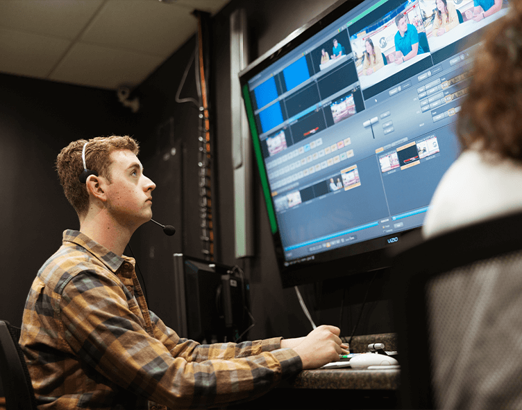 Students editing video footage on computer monitor