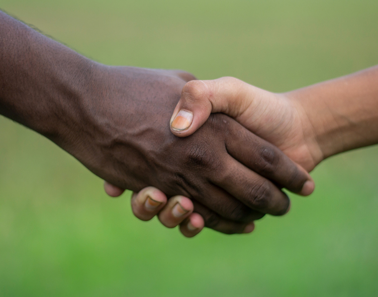 two people shaking hands on an athletic field